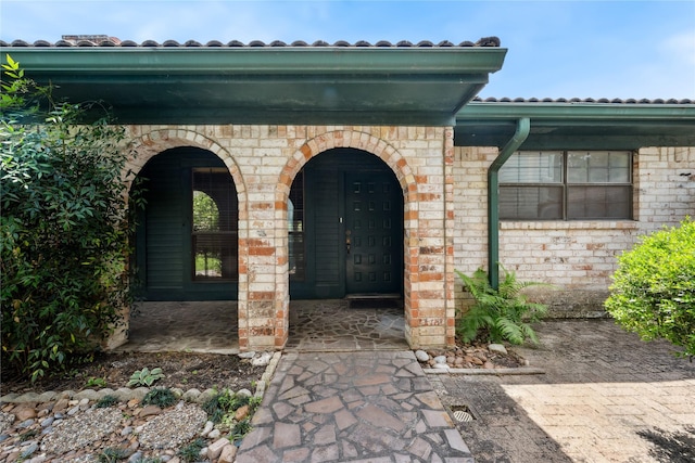 view of exterior entry with brick siding