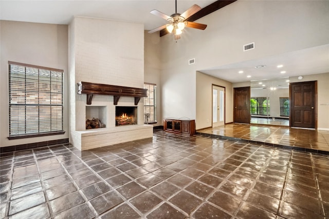 unfurnished living room featuring high vaulted ceiling, baseboards, ceiling fan, and visible vents