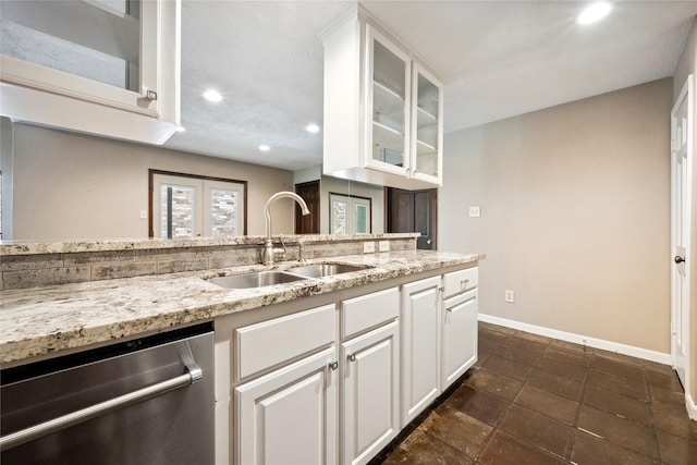 kitchen with stainless steel dishwasher, a sink, light stone counters, and recessed lighting