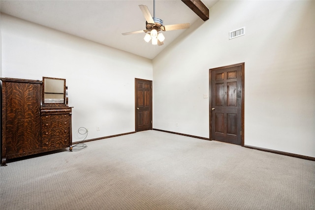 unfurnished bedroom featuring visible vents, beam ceiling, baseboards, high vaulted ceiling, and carpet flooring