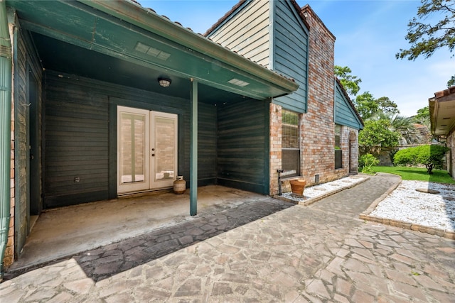 back of house featuring french doors, a patio area, and brick siding