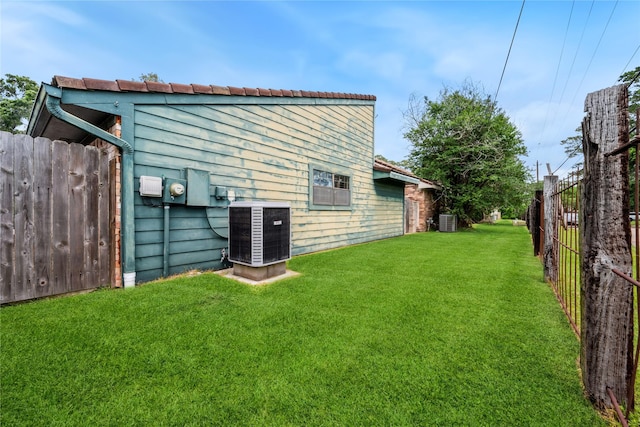 exterior space featuring fence, a yard, and cooling unit