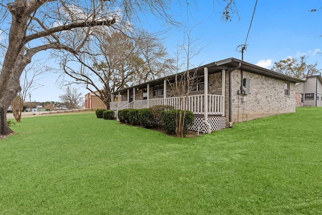 10 Hillcrest St, Point Blank, TX 77364 - rear view of house with brick siding, a yard, and a porch