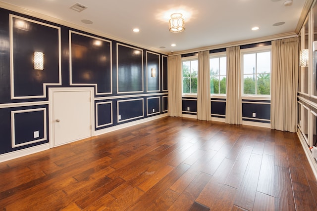 spare room with ornamental molding, hardwood / wood-style floors, and visible vents