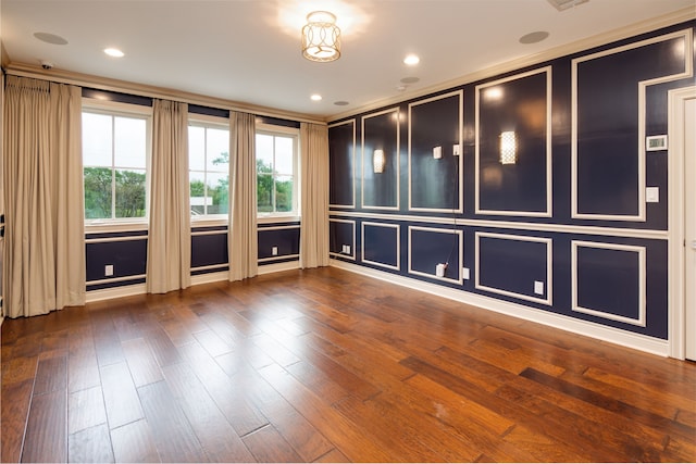 unfurnished room with hardwood / wood-style floors and a decorative wall