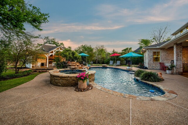outdoor pool with a patio and an in ground hot tub