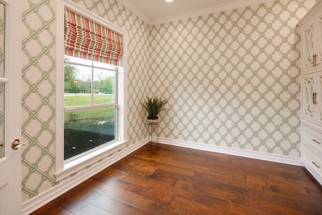 unfurnished room featuring wallpapered walls, baseboards, crown molding, and dark wood-style floors