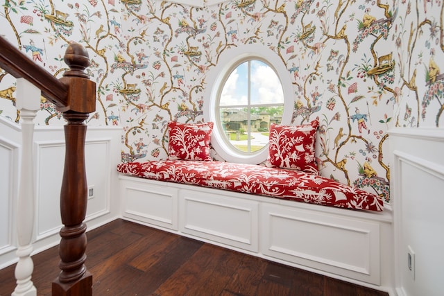 living area with a decorative wall, dark wood-style flooring, a wainscoted wall, and wallpapered walls