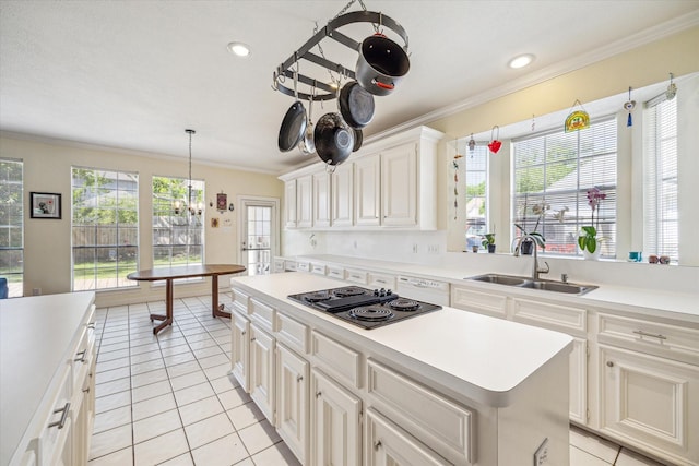 7930 Tizerton Ct, Spring, TX 77379 - kitchen with a sink, black electric stovetop, ornamental molding, light tile patterned flooring, and light countertops