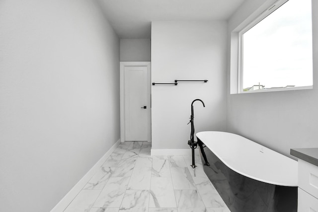 6817 Peerless St, Houston, TX 77021 - bathroom featuring vanity, marble finish floor, baseboards, and a freestanding tub