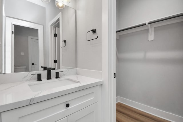 6817 Peerless St, Houston, TX 77021 - bathroom featuring toilet, vanity, wood finished floors, and baseboards