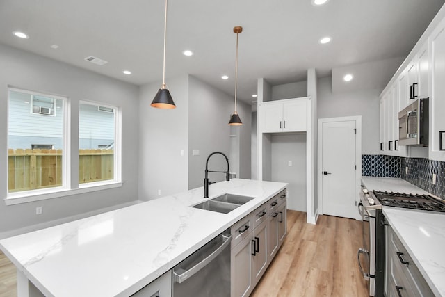 6817 Peerless St, Houston, TX 77021 - kitchen with a sink, visible vents, recessed lighting, light wood-style floors, and appliances with stainless steel finishes