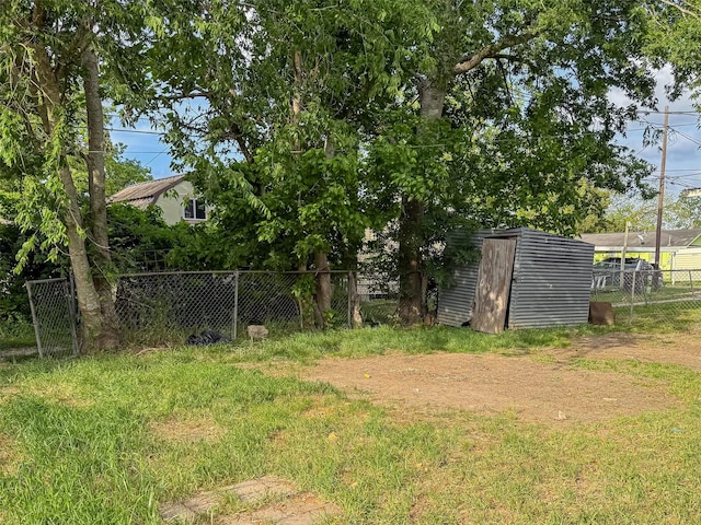 view of yard with an outdoor structure, a shed, and fence
