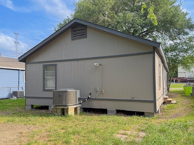 view of home's exterior featuring central air condition unit and a lawn