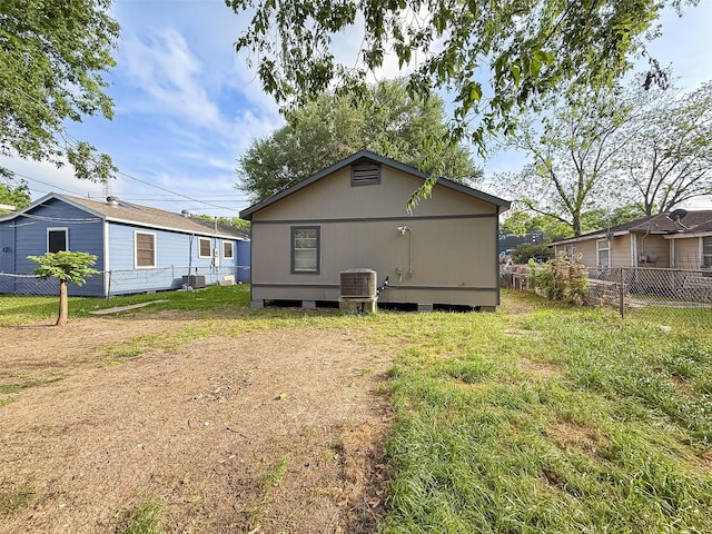 rear view of property featuring central AC and fence