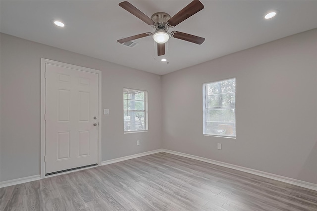 unfurnished room with light wood-style floors, a ceiling fan, and baseboards