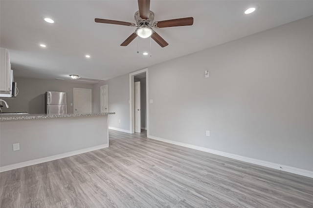 unfurnished living room with a ceiling fan, light wood-style flooring, a sink, and recessed lighting