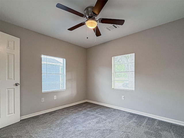 carpeted spare room featuring visible vents, a ceiling fan, and baseboards