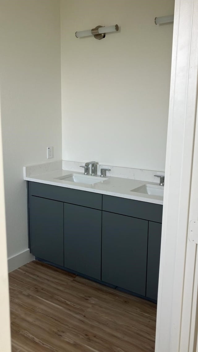 2105 Holman St, Houston, TX 77004 - bathroom featuring double vanity, wood finished floors, baseboards, and a sink