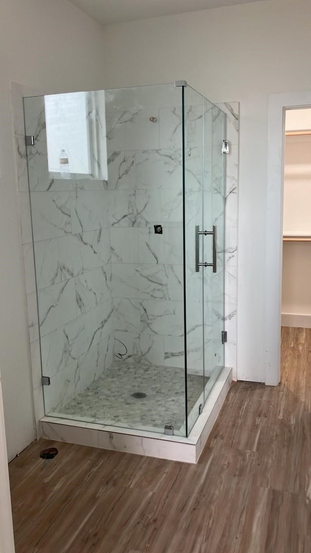 2105 Holman St, Houston, TX 77004 - full bathroom with a walk in closet, wood finished floors, and a marble finish shower