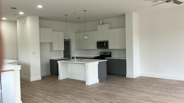 2105 Holman St, Houston, TX 77004 - kitchen with light wood-style floors, a kitchen island with sink, stainless steel appliances, and a sink