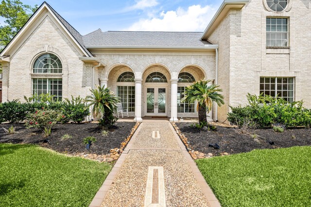 13602 Copeland Oaks Blvd, Cypress, TX 77429 - entrance to property featuring french doors, brick siding, roof with shingles, and a yard