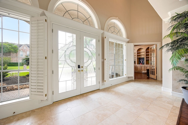 entryway featuring high vaulted ceiling, light tile patterned floors, and french doors