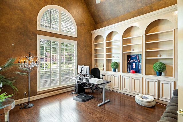 home office featuring high vaulted ceiling, dark wood-style flooring, built in features, baseboards, and a notable chandelier