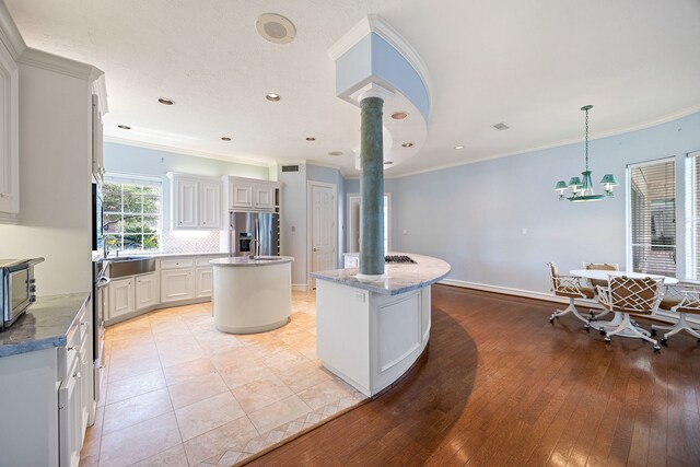 13602 Copeland Oaks Blvd, Cypress, TX 77429 - kitchen with a center island, stainless steel fridge, crown molding, recessed lighting, and backsplash