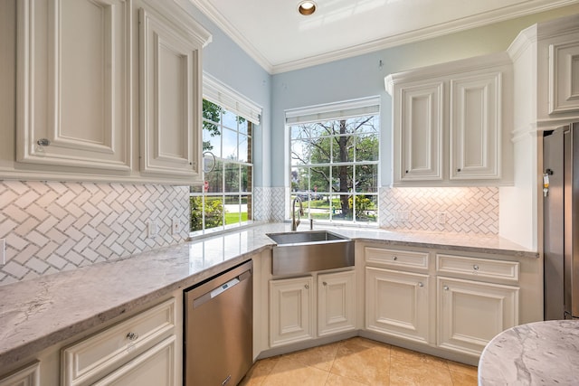 kitchen featuring decorative backsplash, light stone countertops, stainless steel appliances, and a sink