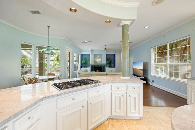 13602 Copeland Oaks Blvd, Cypress, TX 77429 - kitchen featuring stainless steel gas cooktop, light stone counters, ceiling fan, open floor plan, and ornamental molding