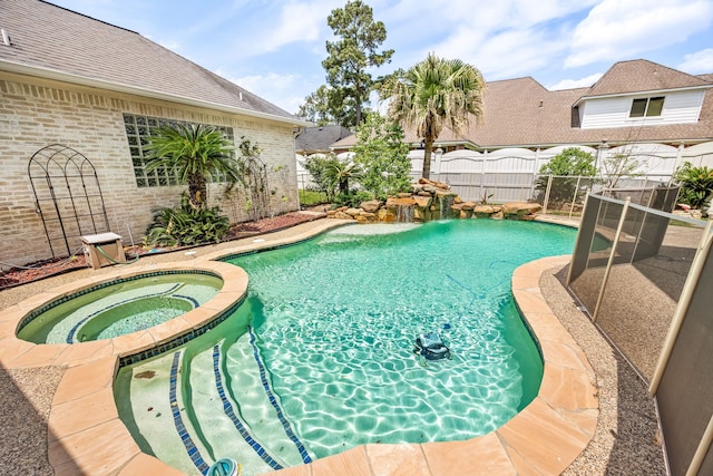 view of pool featuring fence and a pool with connected hot tub
