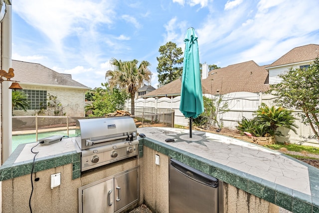 view of patio / terrace with an outdoor kitchen, a fenced backyard, and area for grilling