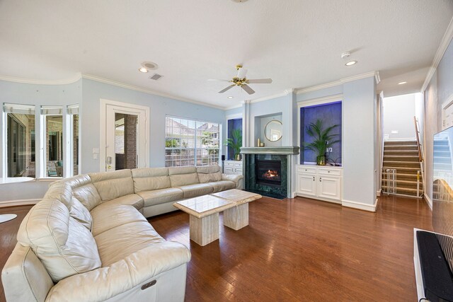 13602 Copeland Oaks Blvd, Cypress, TX 77429 - living room with a ceiling fan, dark wood-type flooring, ornamental molding, a premium fireplace, and stairs