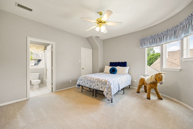 bedroom featuring carpet flooring, ensuite bathroom, baseboards, visible vents, and a ceiling fan