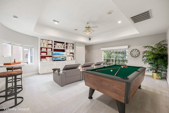 playroom featuring light carpet, a ceiling fan, visible vents, and a raised ceiling