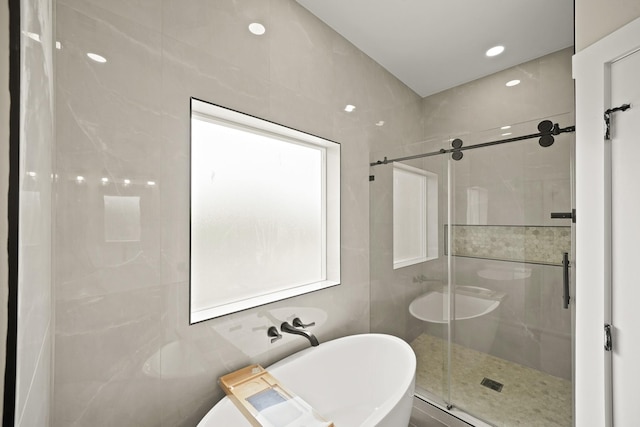 bathroom featuring a shower stall and a freestanding tub