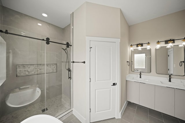 full bathroom featuring double vanity, a shower stall, tile patterned flooring, and a sink