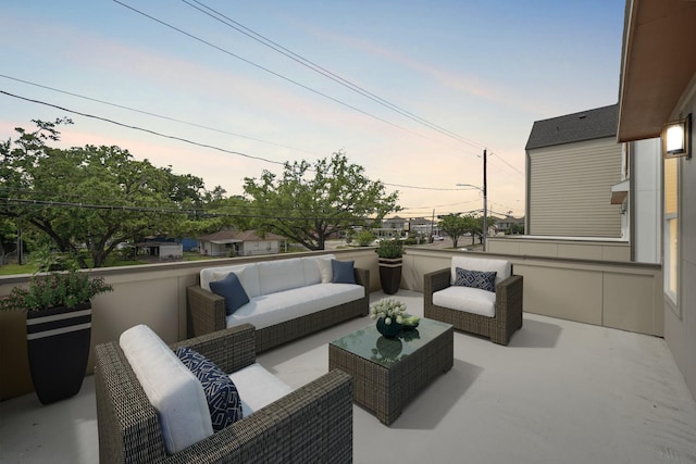 patio terrace at dusk with outdoor lounge area and a balcony