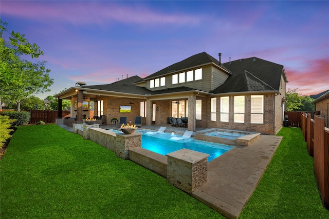 back of property featuring a lawn, a patio, brick siding, and a fenced backyard