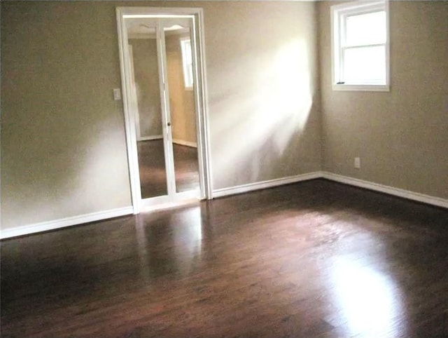 empty room featuring baseboards and wood finished floors