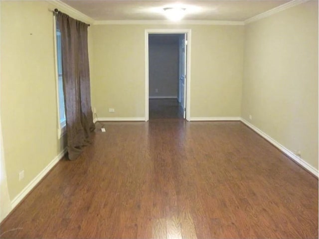 spare room with baseboards, wood finished floors, and ornamental molding