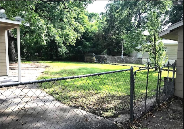 view of yard with a fenced backyard and a gate