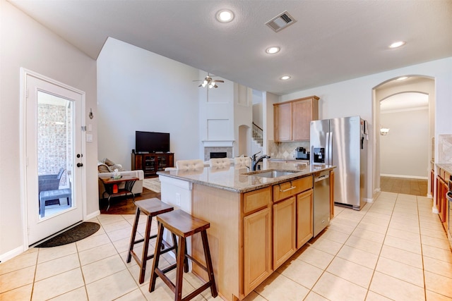 5002 Sawmill Terrace Ln, Spring, TX 77389 - kitchen featuring a sink, appliances with stainless steel finishes, arched walkways, a ceiling fan, and light tile patterned floors