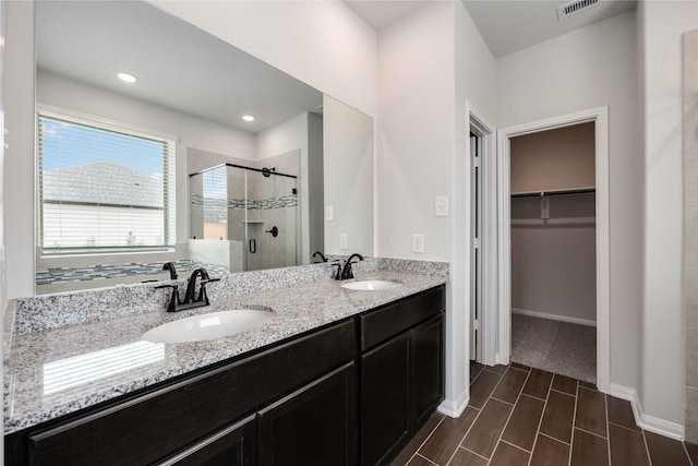 600 Barton Place Dr, Cleveland, TX 77327 - bathroom featuring a shower stall, a walk in closet, and double vanity
