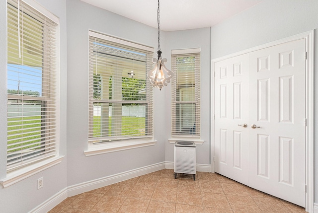 unfurnished dining area featuring baseboards, a wealth of natural light, and light tile patterned flooring