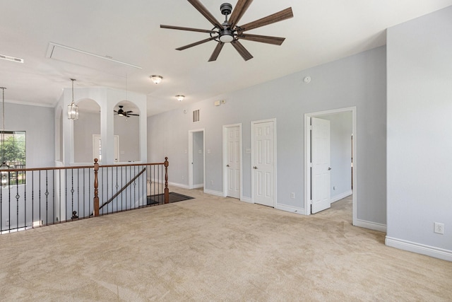 carpeted spare room featuring attic access, visible vents, a ceiling fan, and baseboards