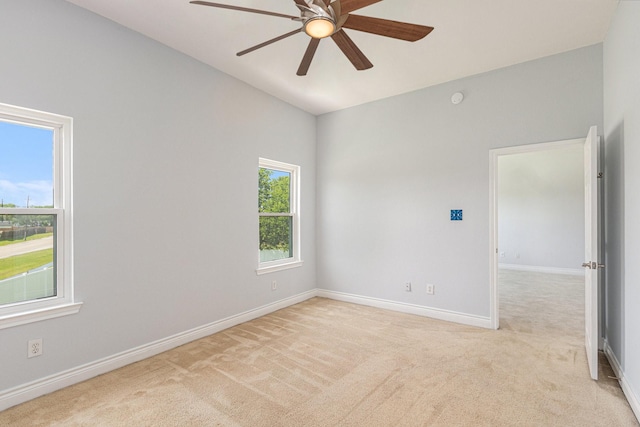 unfurnished room featuring ceiling fan, lofted ceiling, baseboards, and light carpet