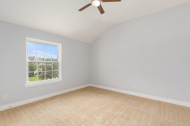 spare room featuring baseboards, vaulted ceiling, light colored carpet, and ceiling fan