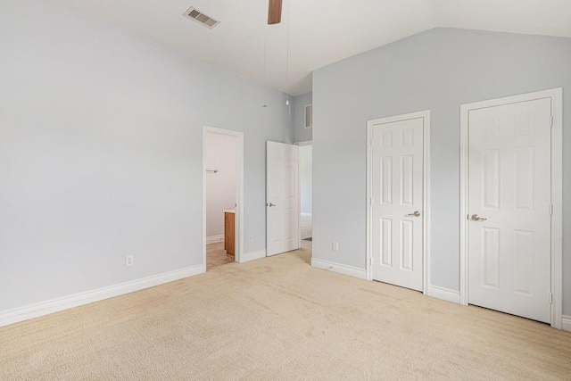 unfurnished bedroom featuring baseboards, visible vents, light colored carpet, lofted ceiling, and connected bathroom
